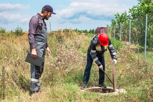 Municipal utility workers have opened a water well and are inspecting the water pipes