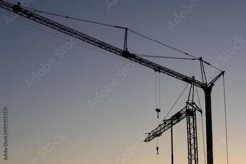 Tower crane silhouettes on blue sky background