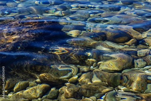 Fototapeta Naklejka Na Ścianę i Meble -  Underwater pebble stones on sea bottom in clear blue water. Natural summer background, beach seascape texture for travel and vacation images