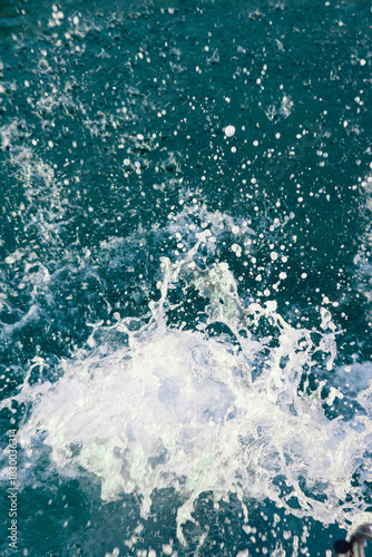 Turquoise sea water with foam splashes after jump from a boat. Fresh summer ocean background, travel, recreation and vacation concept