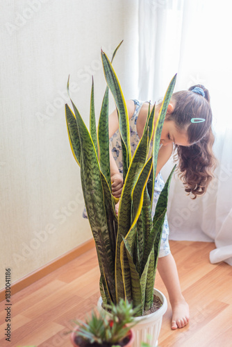 Niña concentrada en cuidar una planta