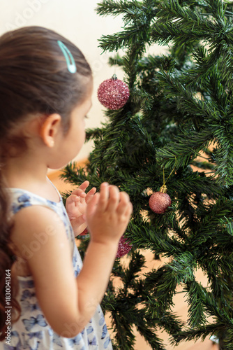 Niña decorando un árbol de Navidad