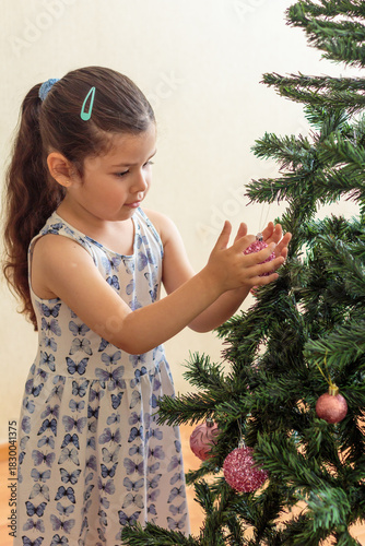 Niña decorando un árbol de Navidad