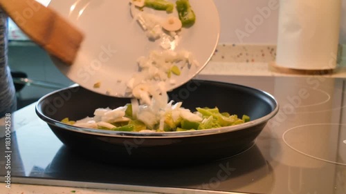 leaving the vegetables from a white plate in the pan to make the sofrito
