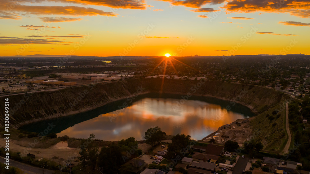 Fototapeta premium Aerial shot of a lake surrounded by homes and lush green trees at sunset in Duarte California USA