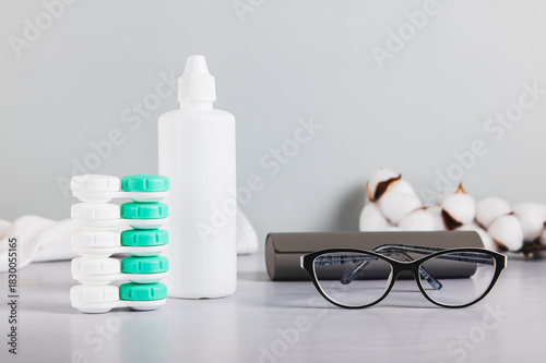 Concept of choosing between glasses and contact lenses on a table