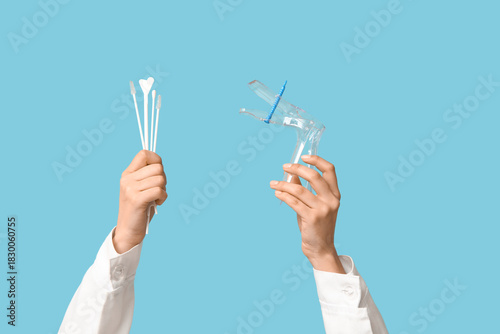 Bild auf Leinwand Doctor's hands with pap test tools on blue background