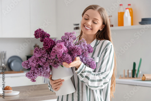Young woman holding vase of...