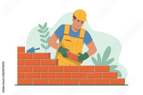Man in yellow overalls laying bricks to build a wall with trowel nearby