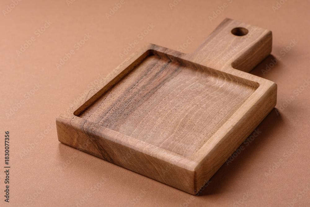 Fototapeta premium Wood, a wooden empty cutting board on a dark kitchen table. Wooden cutting board