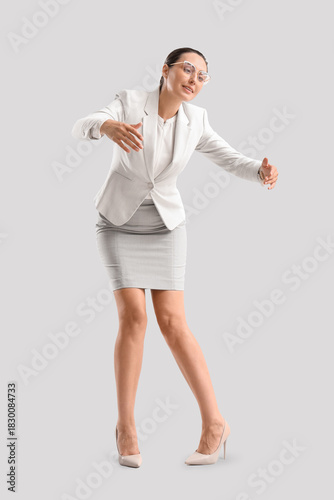 Foto Businesswoman in pose of marionette on light background
