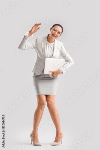 Obraz na płótnie Businesswoman with laptop in pose of marionette on light background