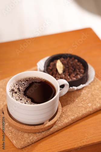 Cup of coffee with coaster ...