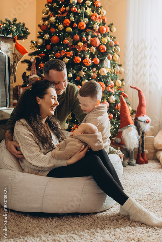 Family celebrating christmas with newborn baby at home