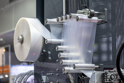 Industrial plastic film extrusion machine with multiple rollers, reels and transparent film, showing the advanced production equipment for efficient production of plastic packaging