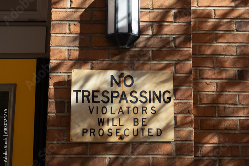 no trespassing sign on brick wall