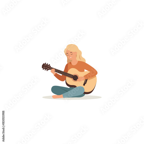 Young woman enjoys playing acoustic guitar while sitting cross legged creating harmonious melodies