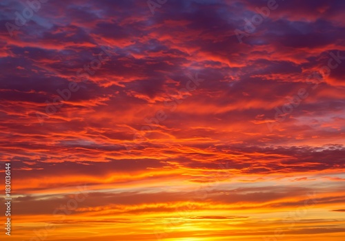 Fiery sunset sky vibrant colors of red orange and yellow across clouds