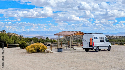 Fotografía RV camper van parked at campsite with covered picnic tables and mountain vista v