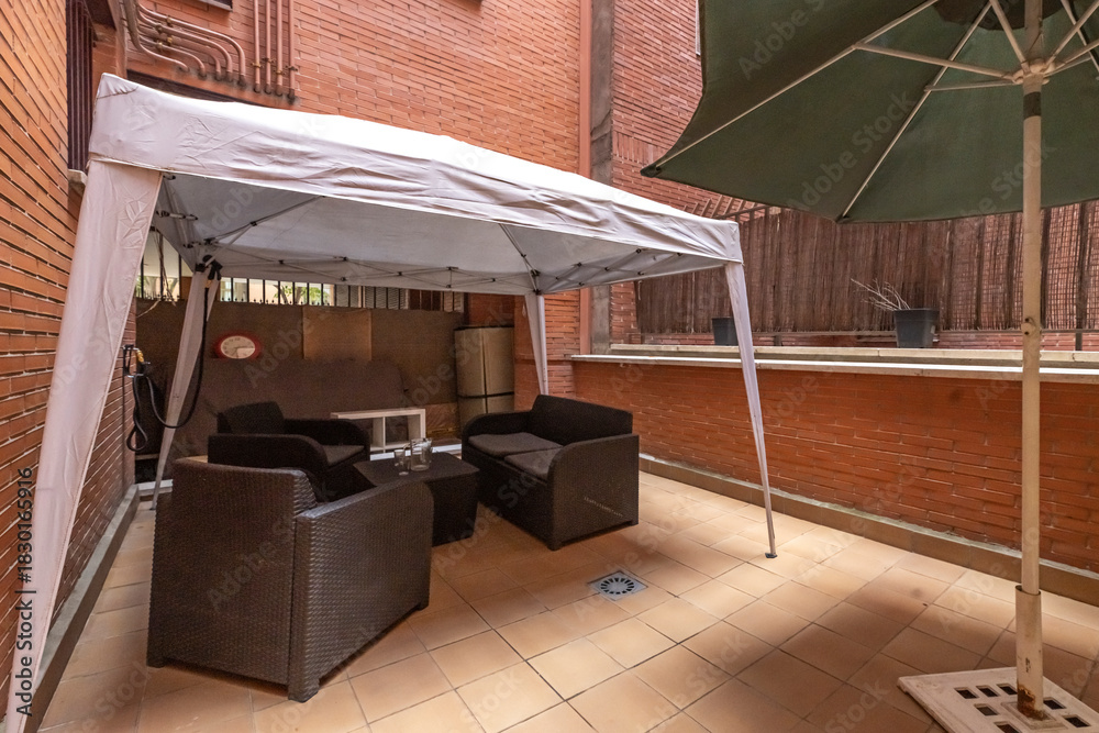 Obraz premium Small urban terrace with a folding table, stackable chairs, and low-maintenance planters for small spaces