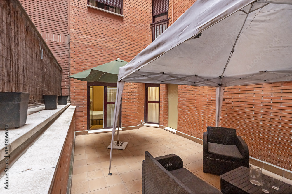 Obraz premium Modern urban terrace with wooden deck flooring, modular outdoor sofa, and vertical garden with integrated LED lighting