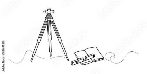 Surveying equipment including a tripod and level tool are arranged on a surface next to an open book, perfect for construction and architectural projects.
