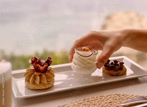 woman's hand  picks up luxurious pastry concoction from plate