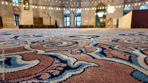 Intricate carpet design in a large mosque interior setting