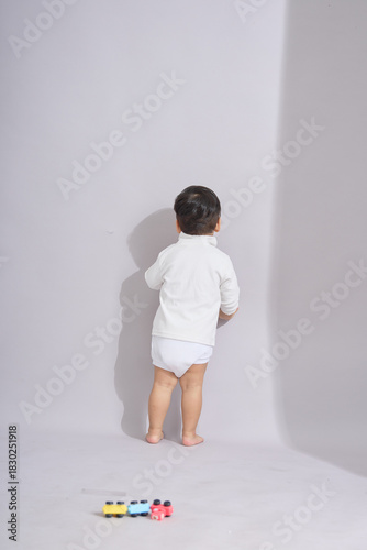 The child walks toward scattered colorful blocks.