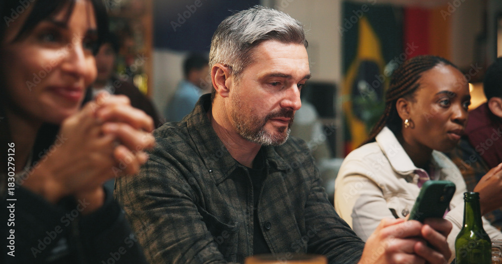 Fototapeta premium Pub, group and man with smartphone, sports betting and checking game results for online competition. Watching, match and gambling with mobile app in bar, entertainment and football fans or people