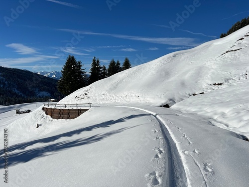 Wonderful winter hiking trails and traces in the fresh alpine snow cover of the Swiss Alps and over the village of St. Antönien - Canton of Grisons, Switzerland (Kanton Graubünden, Schweiz)