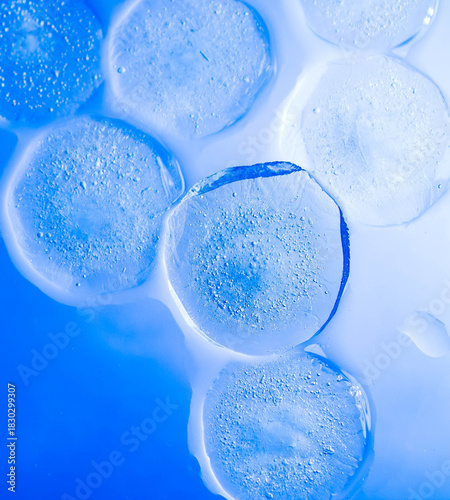 Close-up macro shot of a melting ice cube with frozen air bubbles inside, captured in a dark moody atmosphere. Cold texture, detailed surface, and dramatic lighting create a mysterious, cinematic look
