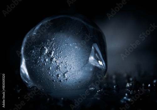 Close-up macro shot of a melting ice cube with frozen air bubbles inside, captured in a dark moody atmosphere. Cold texture, detailed surface, and dramatic lighting create a mysterious, cinematic look
