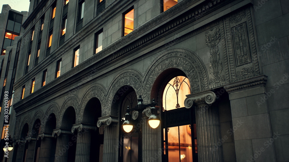 Naklejka premium A grand historic building features intricate arches and detailed architecture. The warm glow of lights from the windows creates an inviting atmosphere in the early evening.