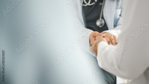 Obraz na plátne Close-up of a doctor holding a patient’s hands, symbolizing medical consultation, compassionate care, professional support, and trust within a healthcare service setting