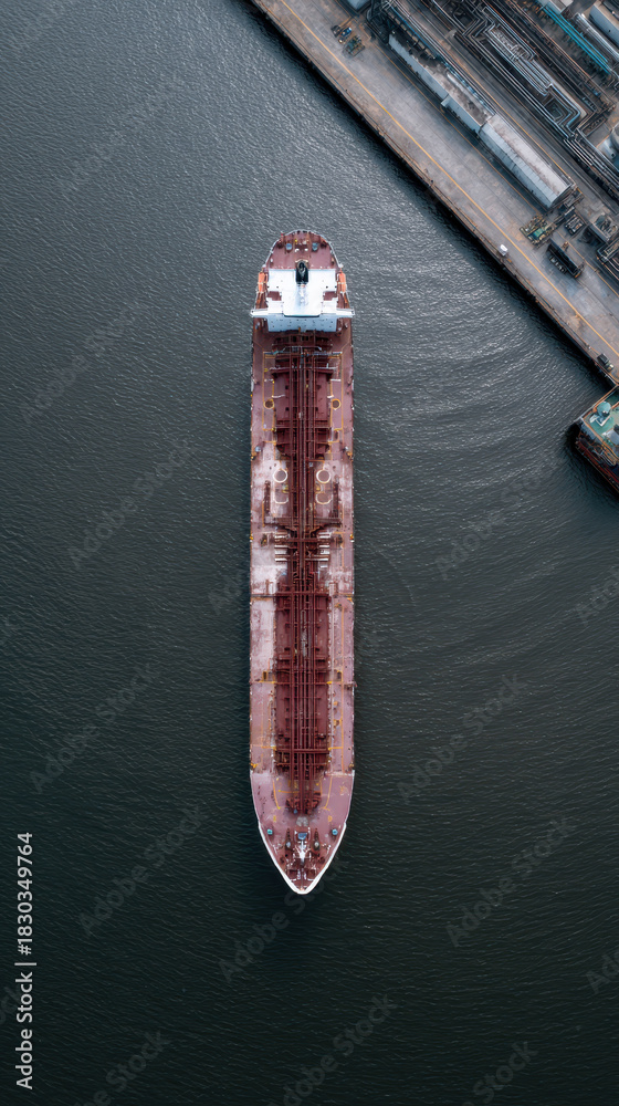 Fototapeta premium Aerial view oil tanker docking harbor industrial calm water scene with quiet power