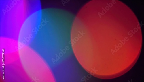 Abstract composition displaying colorful, blurred, circular light orbs against a dark background.