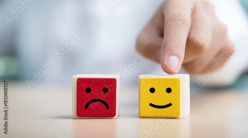 Choosing the Right Emotion: A hand carefully selects a smiling face cube over a sad face cube. This image signifies the impact of choice and the power of emotional control.