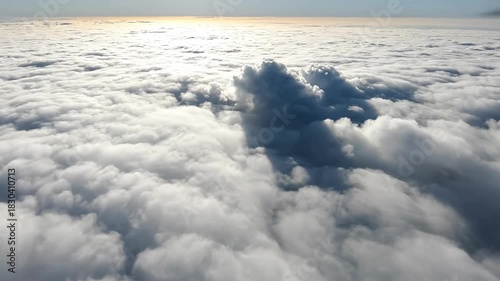 Heavenly Vista: An aerial perspective reveals a sea of billowy clouds illuminated by the soft glow of the sun, creating an atmosphere of tranquility and wonder.