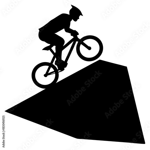 Silhouette of a mountain biker riding down a steep ramp