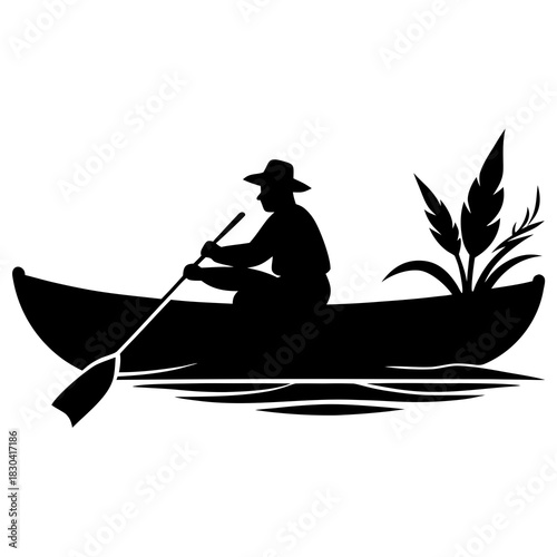 Silhouette of a person rowing a canoe through calm waters with reeds