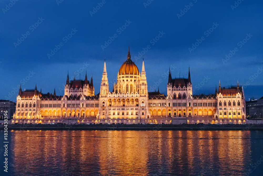 Fototapeta premium Illuminated Hungarian Parliament Building at night reflecting in the Danube River.