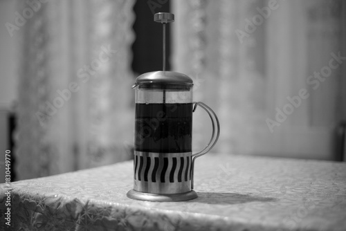  Coffee in a French press on a wooden table. 
