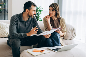 Couple discussing home finances, planning family budget