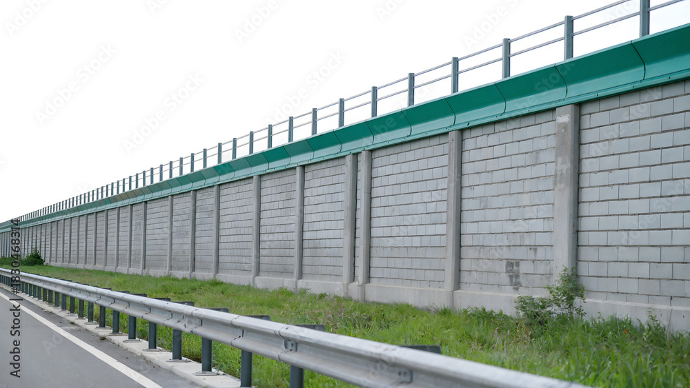 Obraz premium Highway noise barrier with green top enhances community living near urban infrastructure projects serene transport