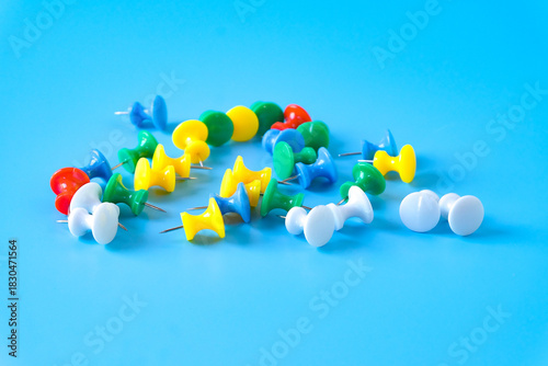 set of colorful push pins on color background.