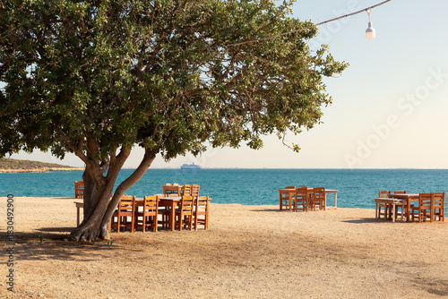 Fototapeta Naklejka Na Ścianę i Meble -  Wooden tables and chairs in a beach park on the Mediterranean coast.