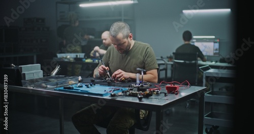 Man Assembling High Speed FPV Drone For Professional Use. Man Intensely Focused on Assembling High Speed FPV Drone, Working on Internal Wiring and Frame. Concept of Growing Field of FPV Technology.
