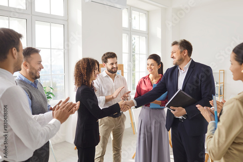 Colleagues in an office celebrate a successful deal during a meeting. A handshake symbolizes teamwork, partnership, and triumph, strengthening their business collaboration and trust.