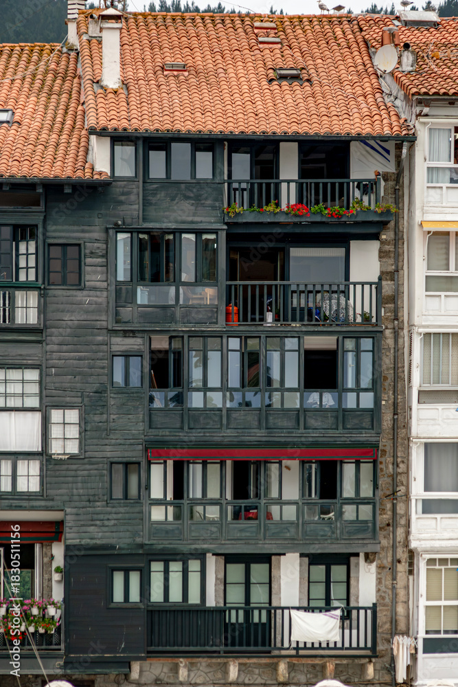 Fototapeta premium Traditional Dark Wood Facade and Balconies of Fishing Village Building in Bermeo